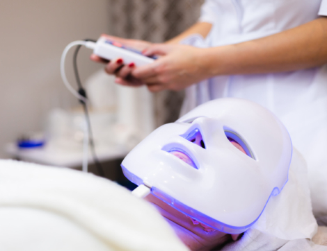 The client lies in the salon on the cosmetology table with a white mask on her face